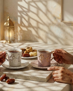 Nous vous proposons un instant de délectation, composé de deux tasses à thé en porcelaine, ornées d'anses dorées et d'une calligraphie arabe en relief, accompagnées de pâtisseries orientales.