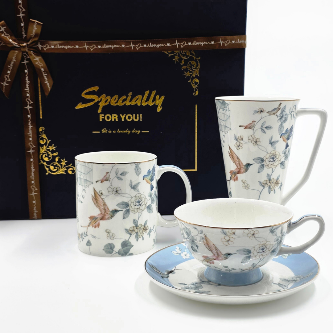 Ensemble en porcelaine avec motifs oiseaux et fleurs devant un coffret cadeau bleu nuit.