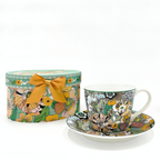 Tasse en porcelaine aux motifs floraux et coffret décoratif assorti, photographie sur fond blanc.