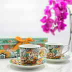Tasses en porcelaine florale avec sous-tasses, présentées devant un coffret cadeau assorti, collection Fêtes de Fin d’Année Majorelle.