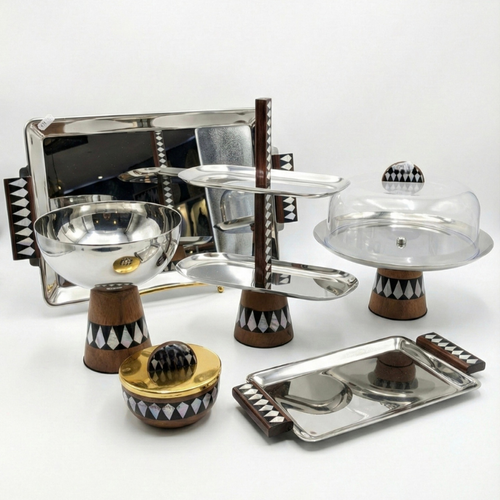 Ensemble de la collection Éclat de Nacre Majorelle : bol, plat à gâteau avec cloche et serviteur muet en acier miroir et bois à marqueterie géométrique.