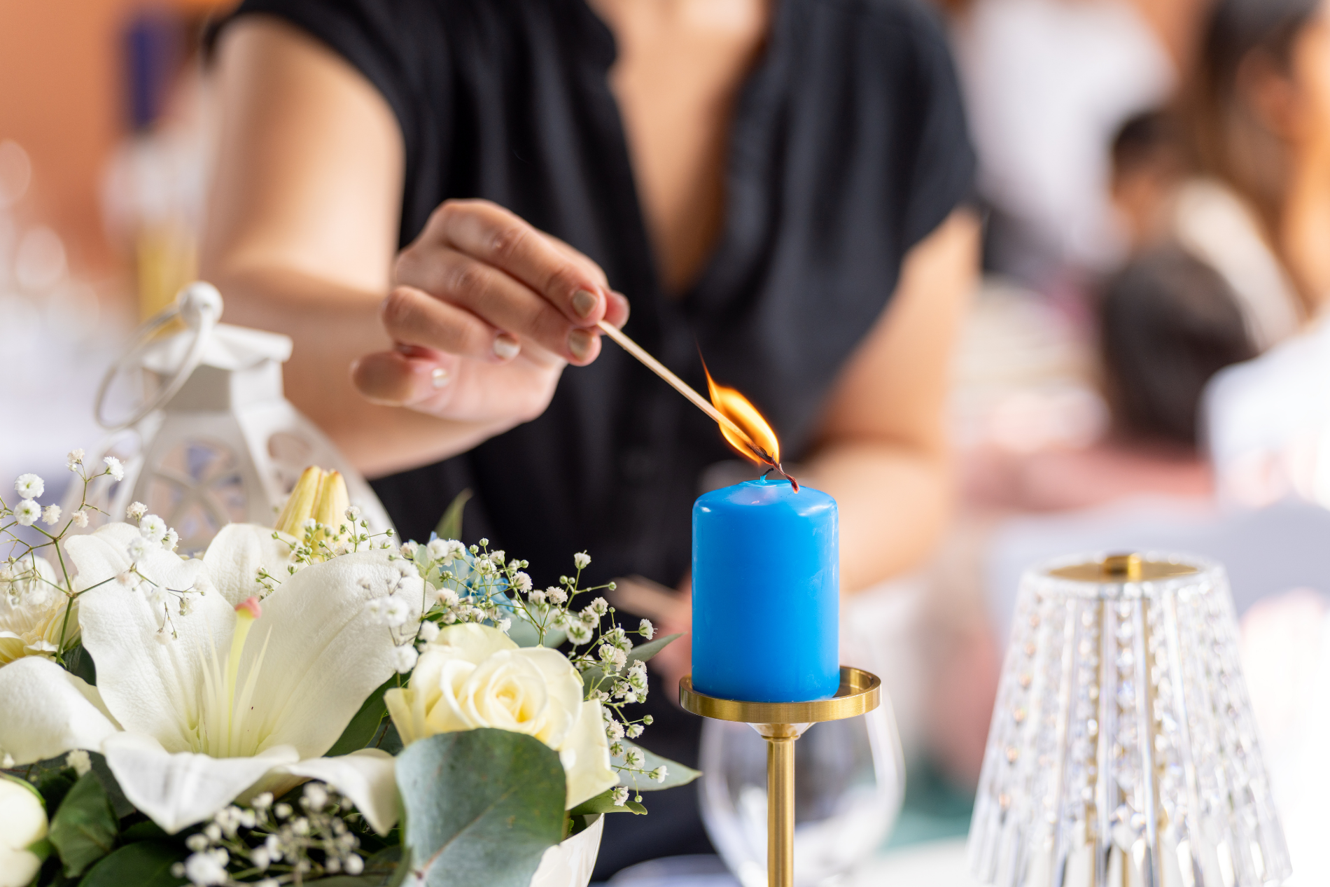 Main allumant une bougie sur une table décorée lors d’un événement organisé par Majorelle Event à La Réunion. Préparation minutieuse et ambiance soignée par l’équipe Majorelle Event.