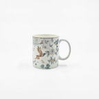 Mug en porcelaine décoré de motifs d’oiseaux et de fleurs sur fond blanc.