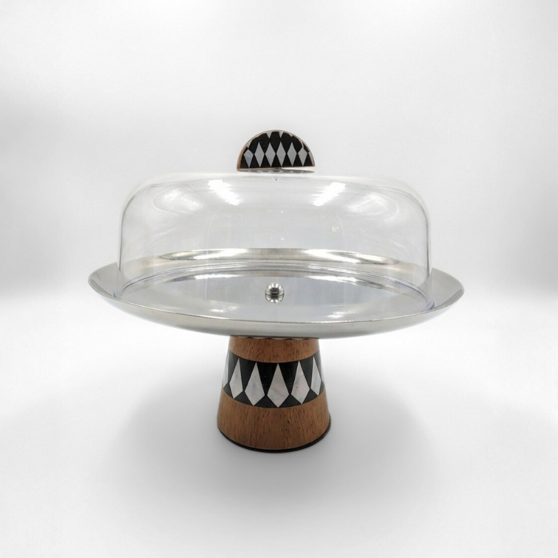 Présentoir à gâteau sur pied "Éclat de Nacre" avec cloche transparente. Socle en marqueterie géométrique noire et blanche et plateau en acier miroir.