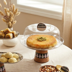 Détail du socle conique en bois avec marqueterie de losanges noirs et blancs du plat à gâteau Éclat de Nacre.