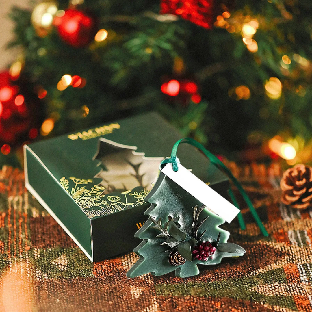Sapin parfumé vert foncé Citta posé avec son coffret, décoration artisanale parfumée pour Noël.