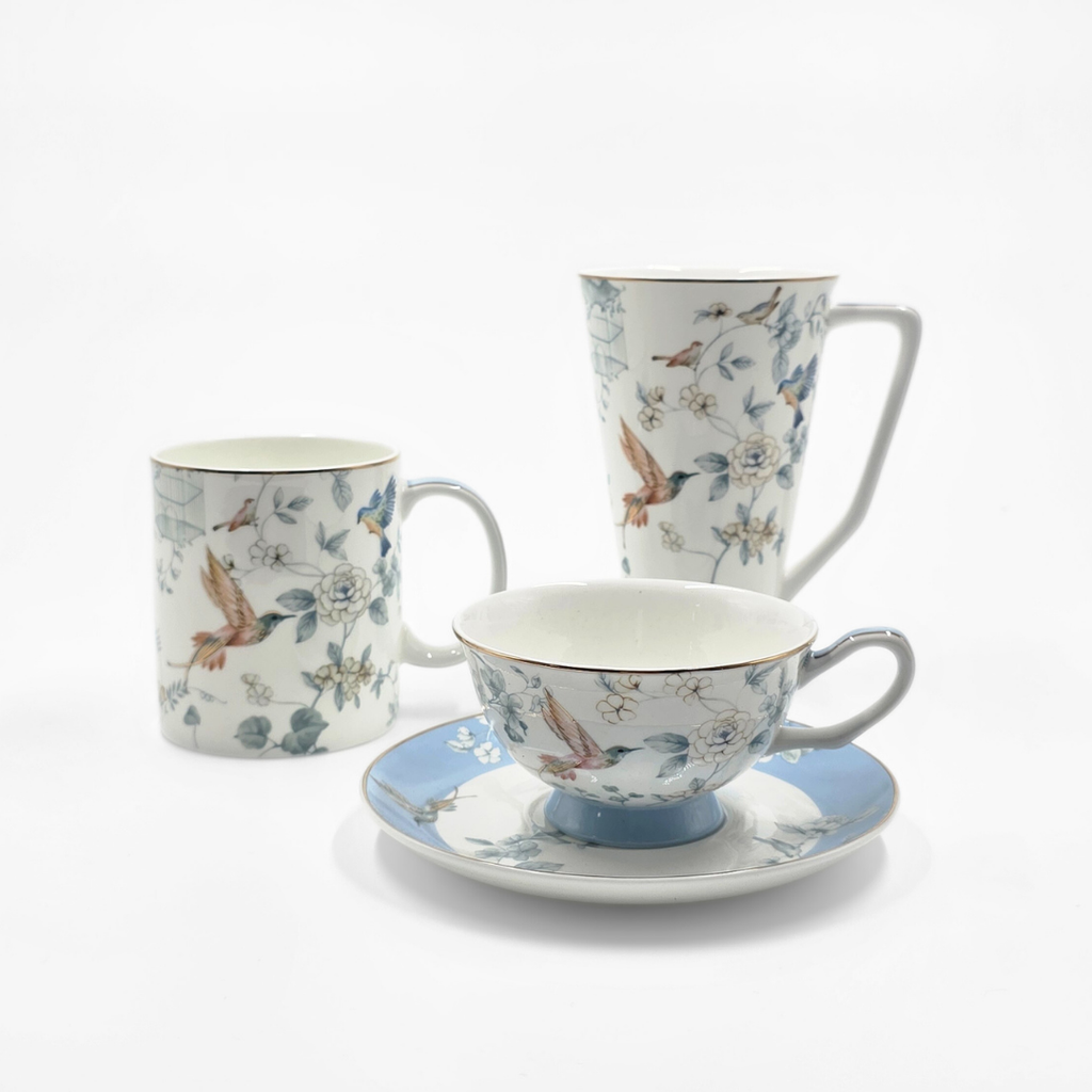 Service de tasses en porcelaine avec motifs floraux et oiseaux sur fond blanc.