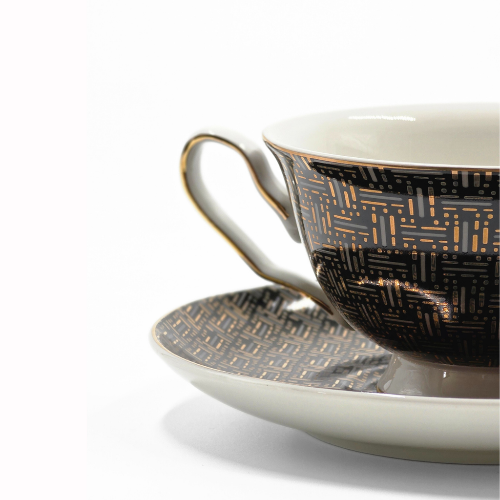 Zoom sur la tasse noir et or avec details dorures et motif graphique