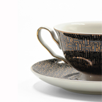 Zoom sur la tasse noir et or avec details dorures et motif graphique