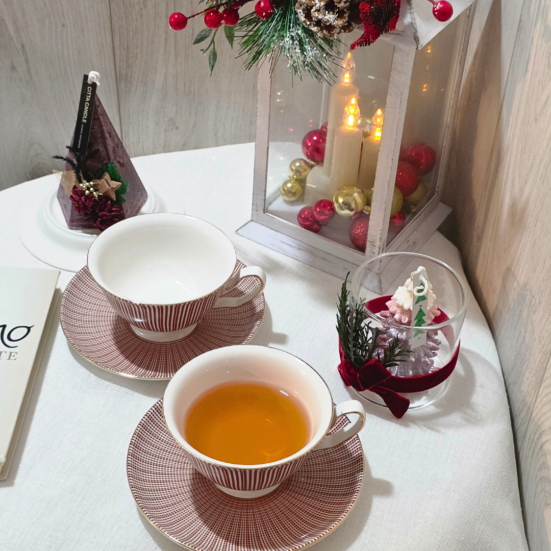 Ensemble tasse et soucoupe rouge motif lignes fines, présenté sur une table decorée pour Noel.