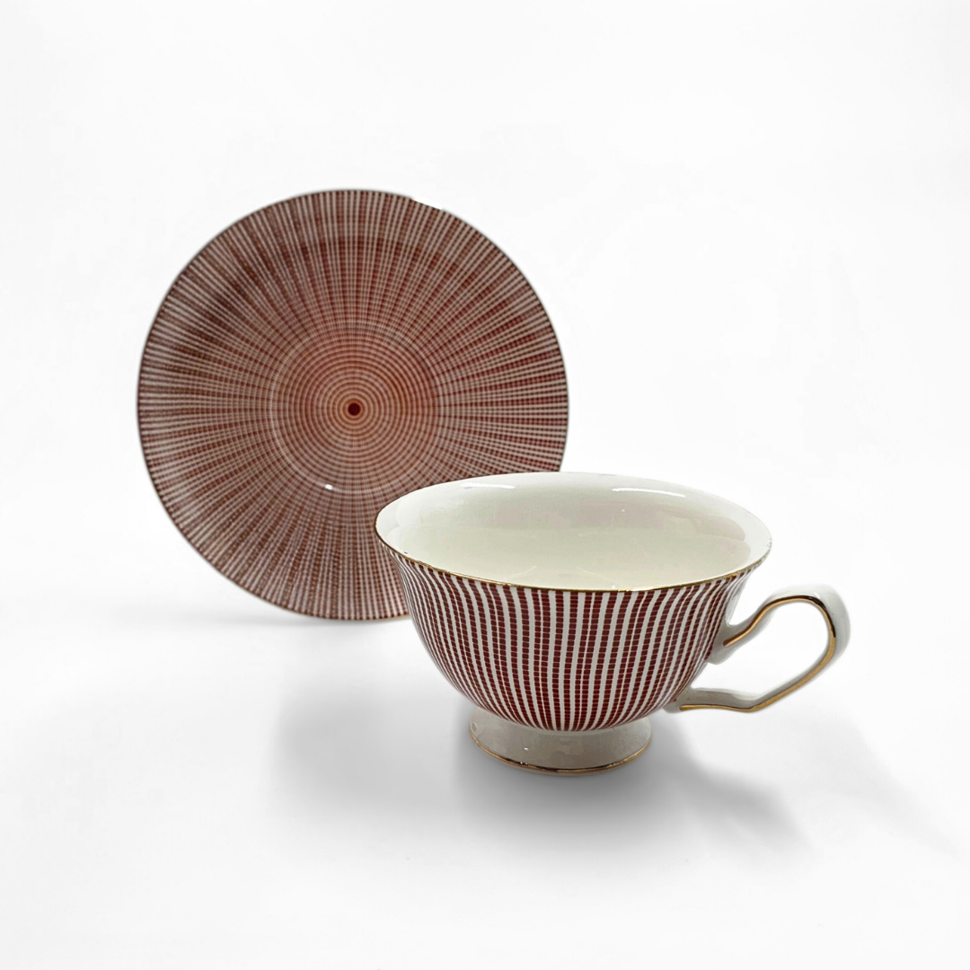 Tasse et soucoupe rouges a motif circulaire exposees en gros plan.