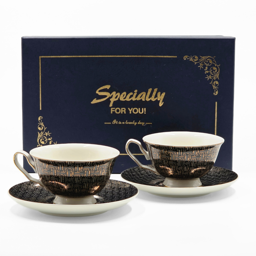 Set de tasses et soucoupes noir et or devant coffret cadeau Majorelle