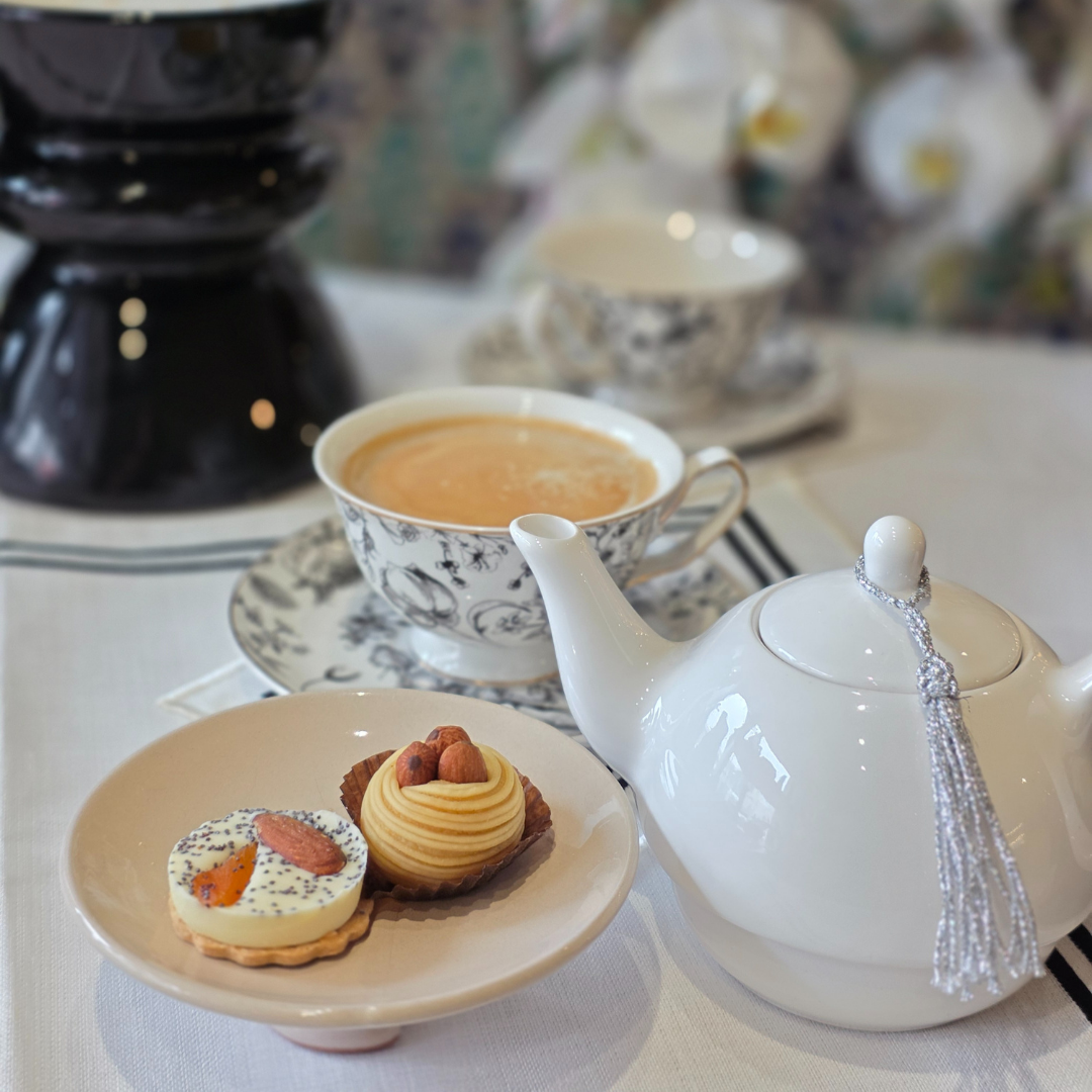 tasses porcelaine vert en situation avec theiere et gateaux ambiance cosy